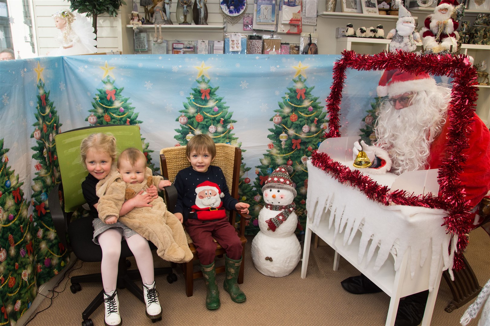 Cassia (L) and Corey (R) and Jordan (being held) Moir...Santa on a visit to The Keith Kilt and Textile Centre in 2020. Picture: Becky Saunderson