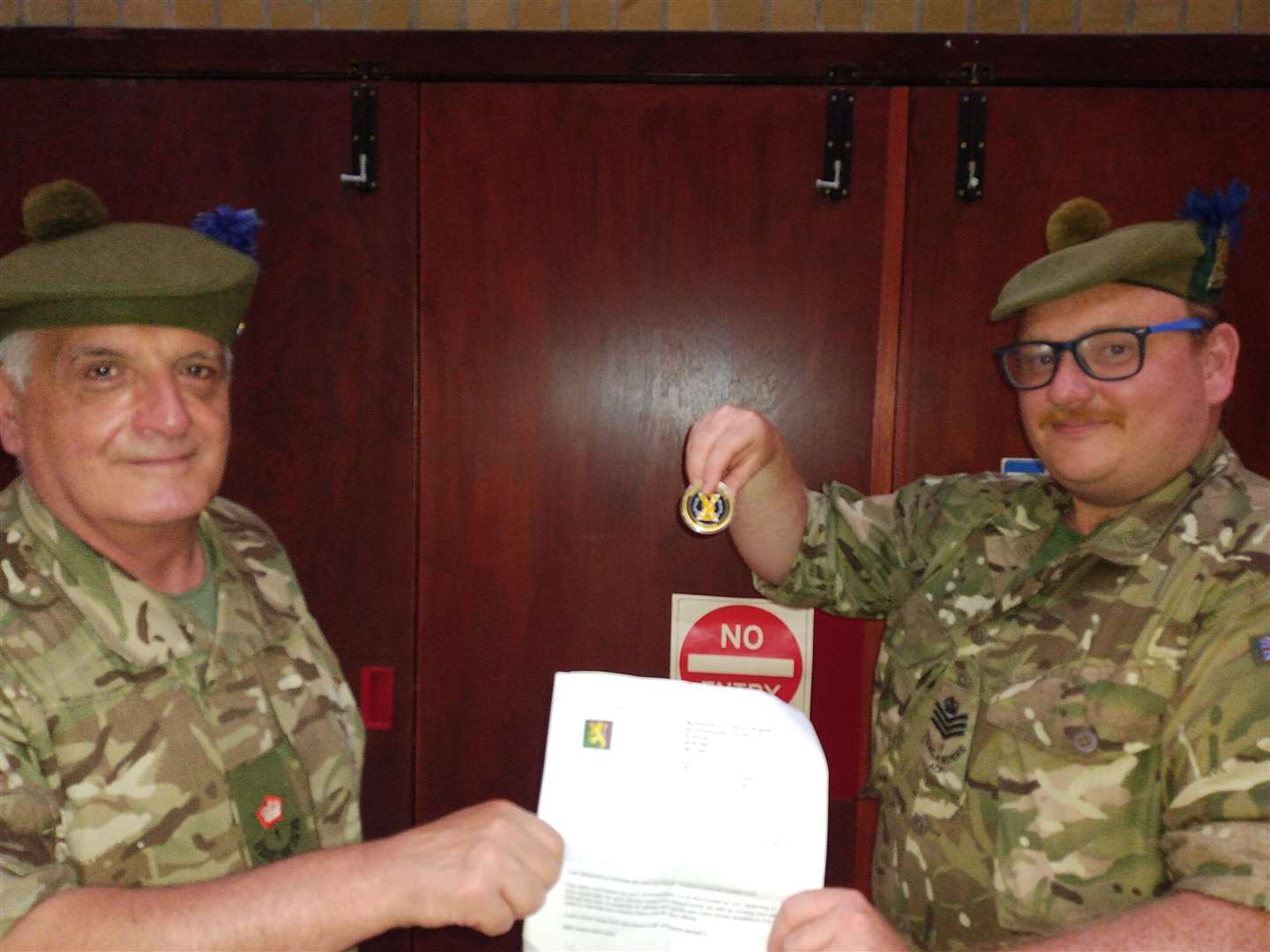 Staff Sergeant Instructor Graeme Wells (right) being presented with his Colonel Cadet Coin and letter of citation from Major Raymond Cameron, Company Commander, Moray Company.