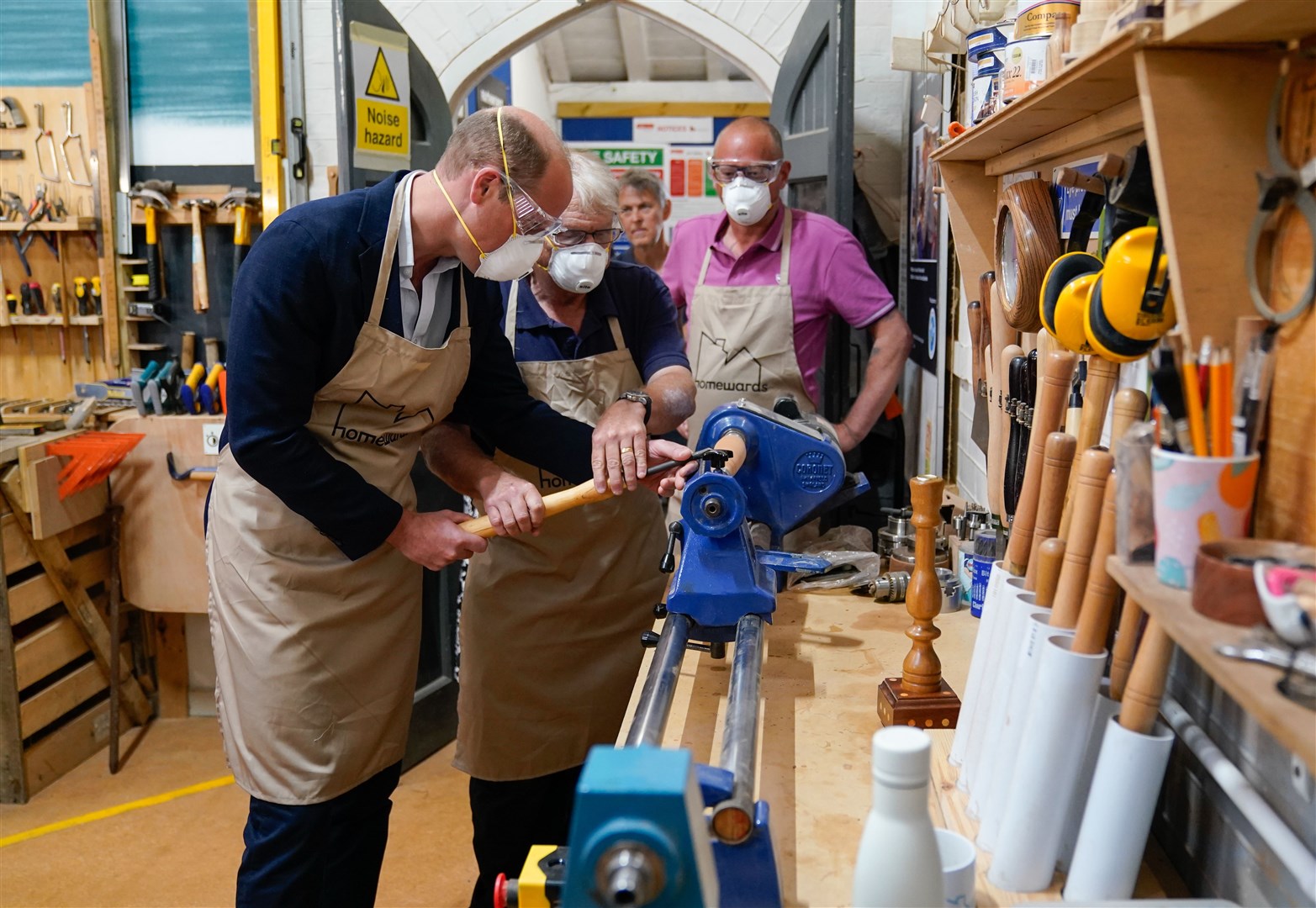 The Prince of Wales uses a lathe during a visit to Faithworks Carpentry Workshop (Andrew Matthews/PA)
