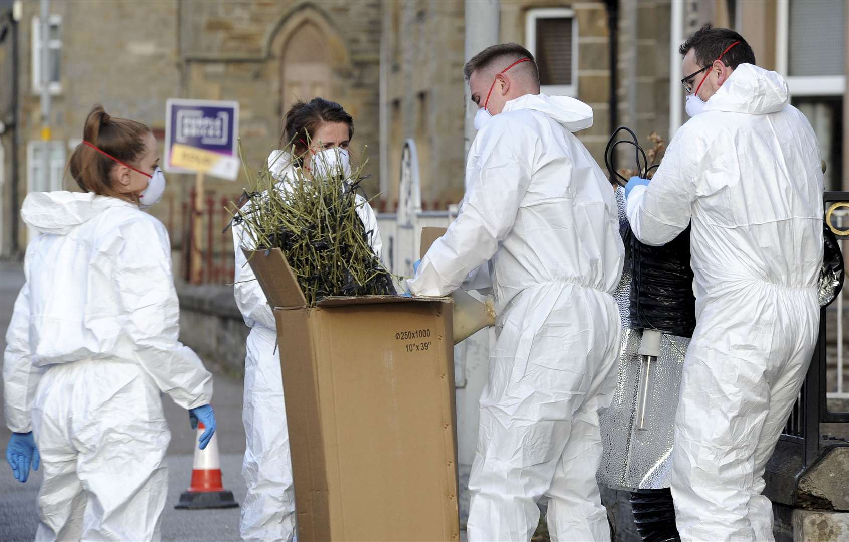Police officers clearing out drug-making equipment.