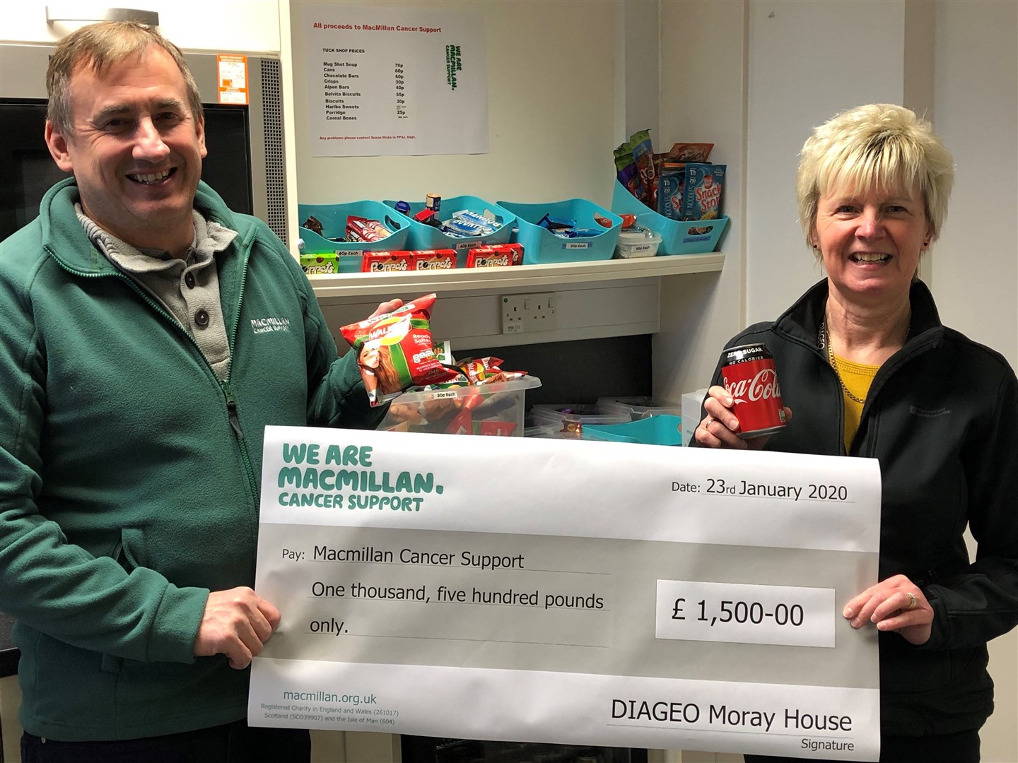 Susan Hicks, who runs the tuck shop, hands over the latest donation for £1500 to David Main, chairman of Elgin District Macmillan Cancer Support Fundraising.