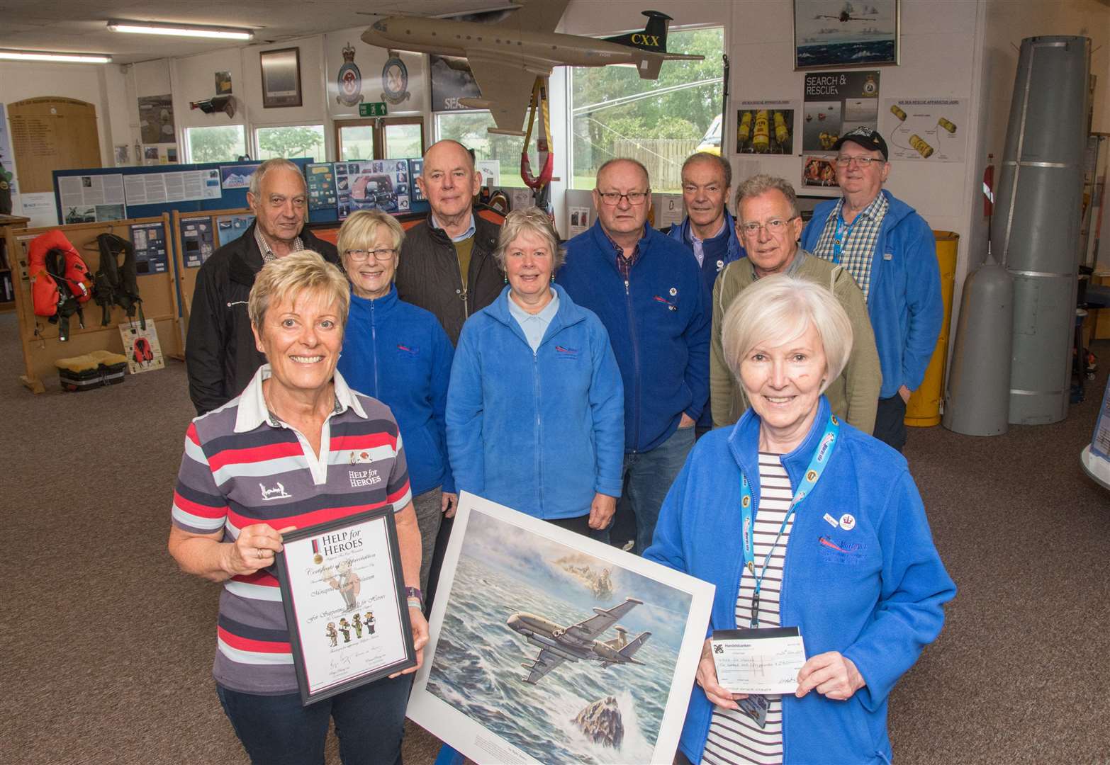Lynne Herbert from Morayvia hands over a cheque for £250 this week to Dianne McLeish of Help for Heroes. The money was raised from the sale of the Nimrod print in the foreground. Picture: Becky Saunderson. Image No.044268.