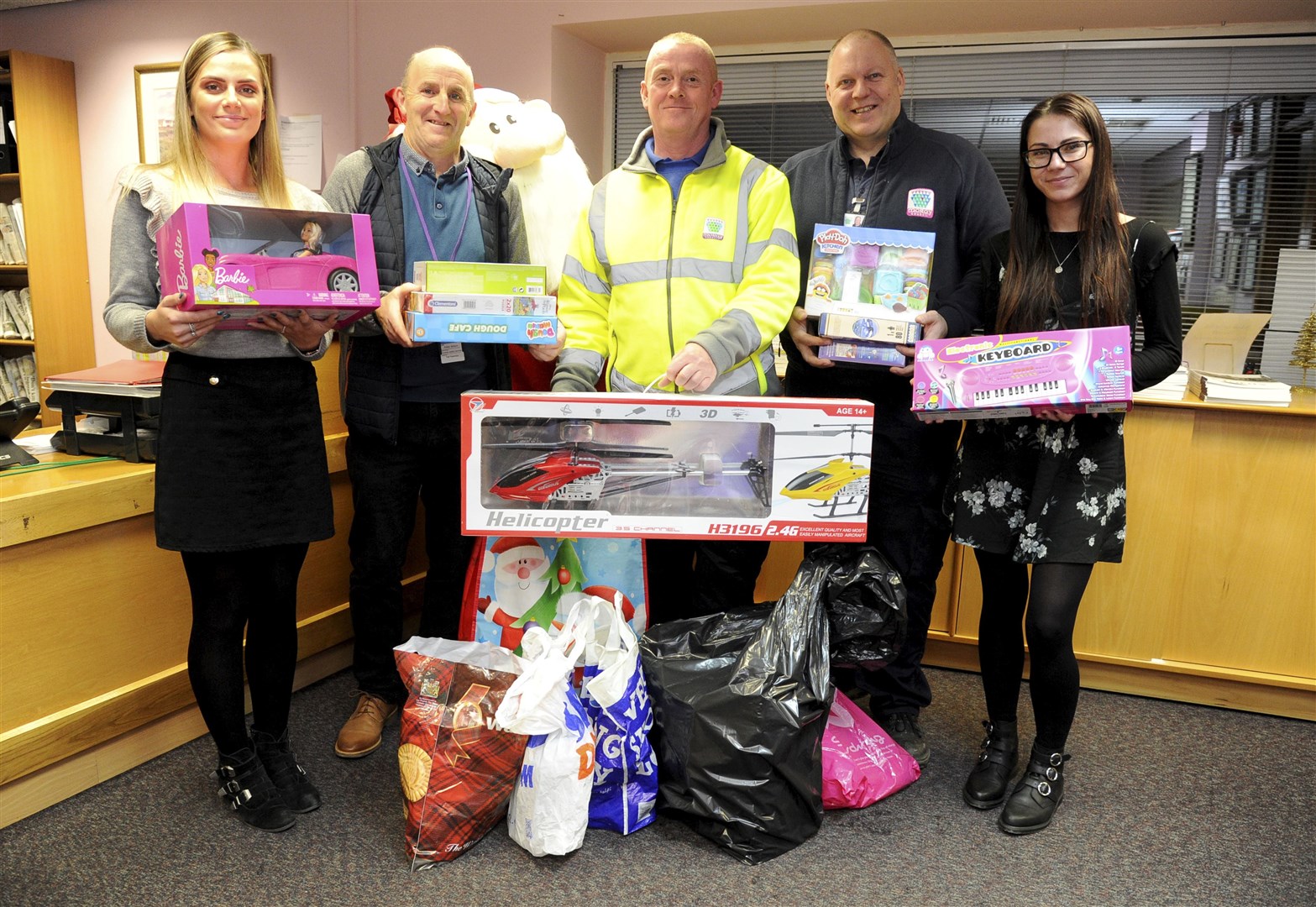 Handing over more toys are Ellie Thompson (left) and Claire Henderson, from the tele sales team at The Scot to Peter Wilson, Paul Borland and Scott Paton from Moray Council. Picture: Eric Cormack