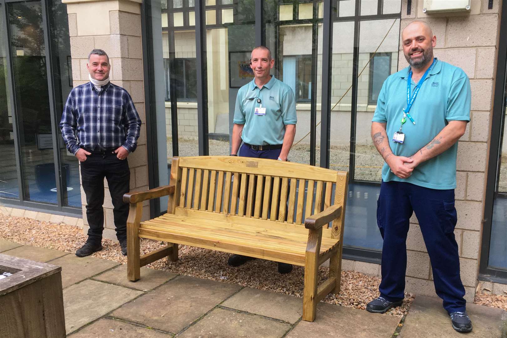 (From left) Ross Gordon, of DRG Services Spey Bay, with Dr Gray's Hospital porters Ritchie Hoe and Tim Wakefield with the new bench for the sensory garden. Picture: Liz Tait.