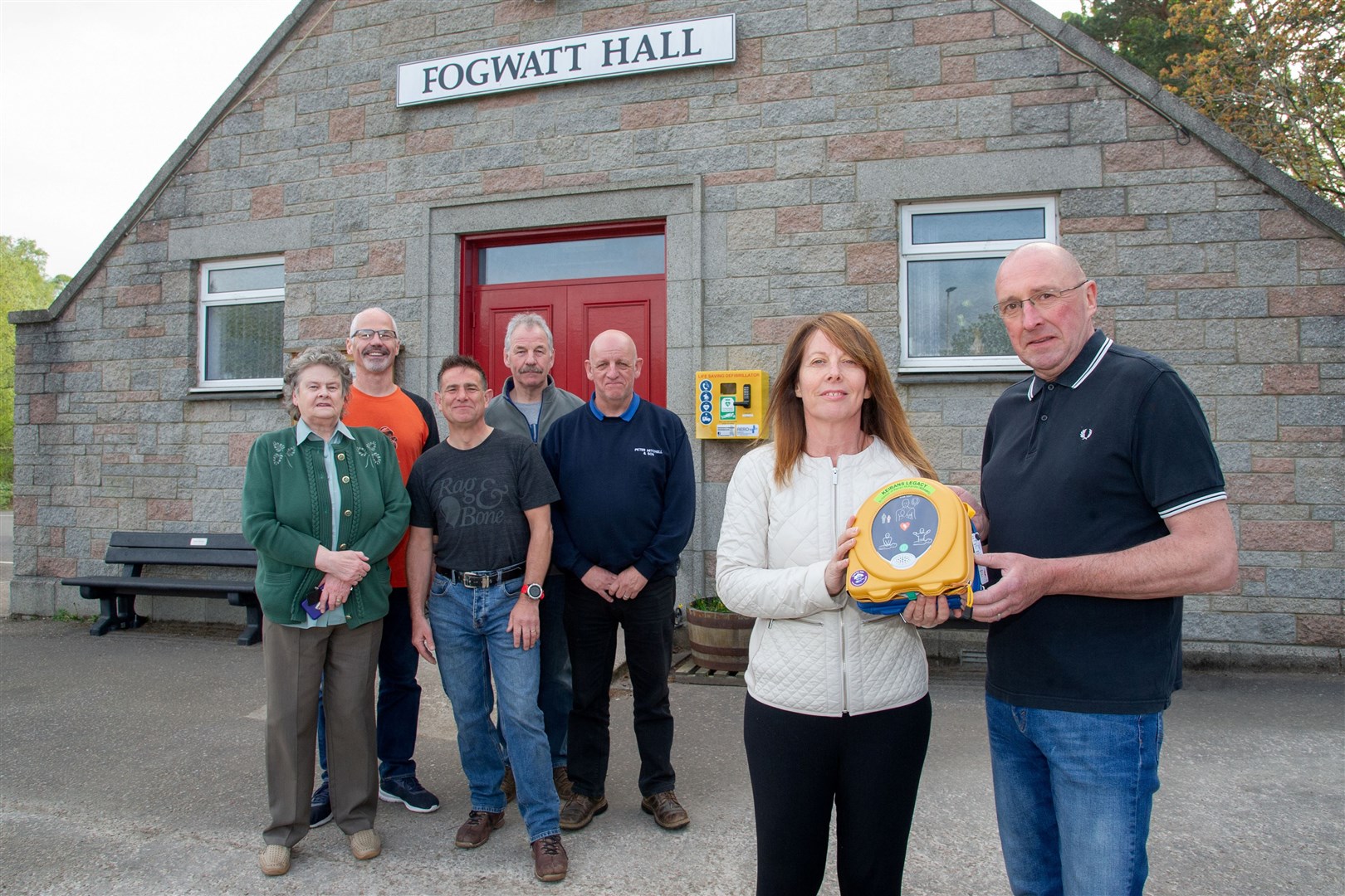 With the new defibrillator outside Fogwatt Hall is Sandra McKandie, who established Keiran’s Legacy in memory of her son, and Hamish Christie from the Fogwatt Hall committee along with other committee members. Picture: Daniel Forsyth. Image No. 043810.