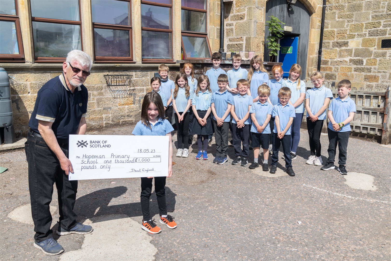 David England handing over a cheque for £1000 to Hopeman Primary School. Picture: Beth Taylor