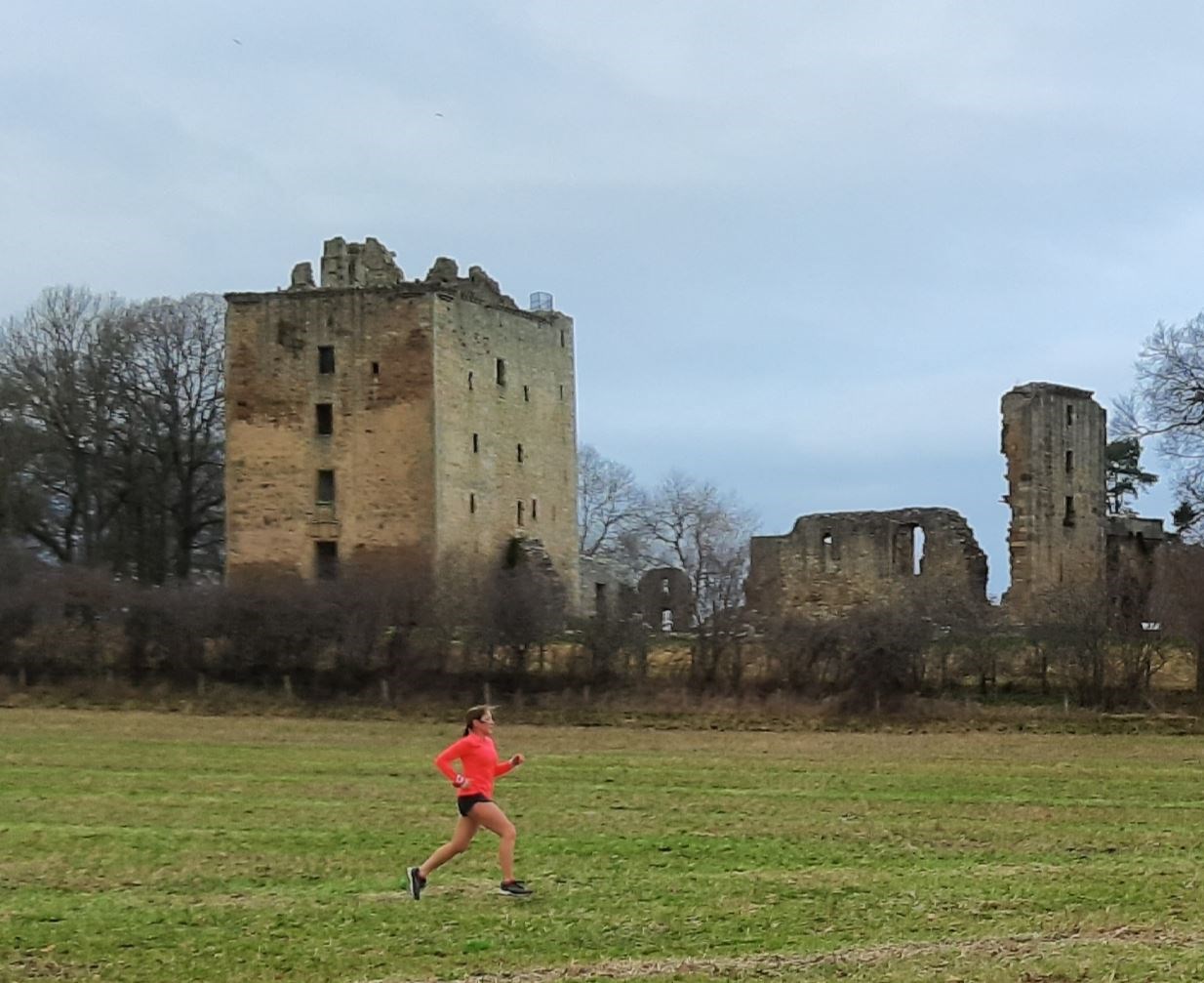 Spynie Palace stands in the background as Sally Bruce runs by.
