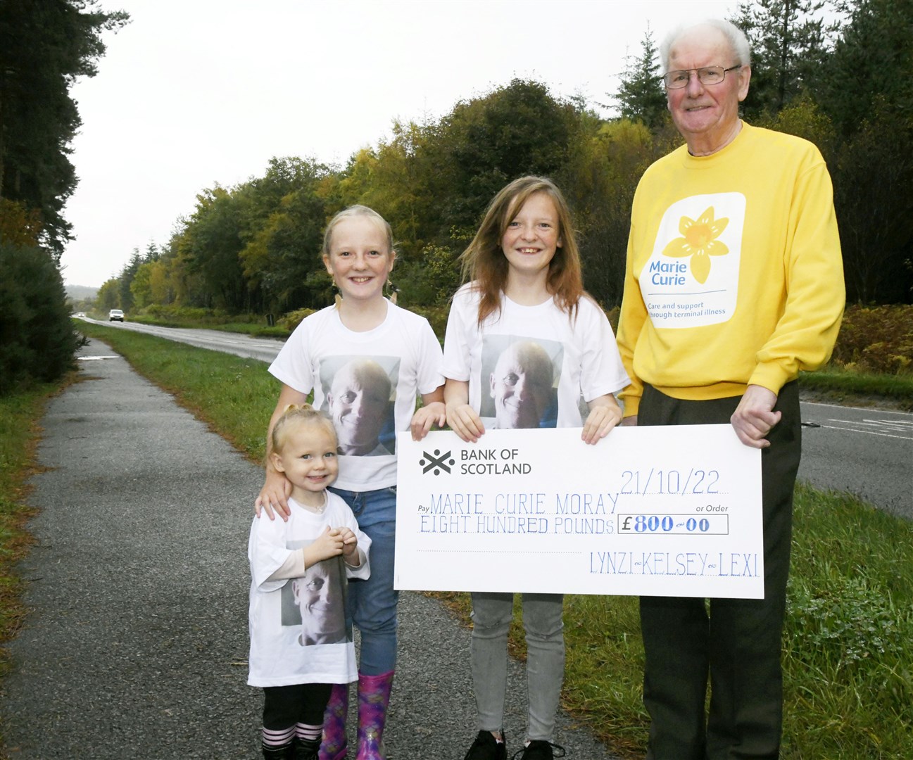 From left: Lexi Stobo, Kelsey Stobo and Lynzi Stobo giving Alan Marshall a cheque for Â£800 to raise money for Marie Curie by walking from Elgin to Lossimouth. ..Picture: Beth Taylor.