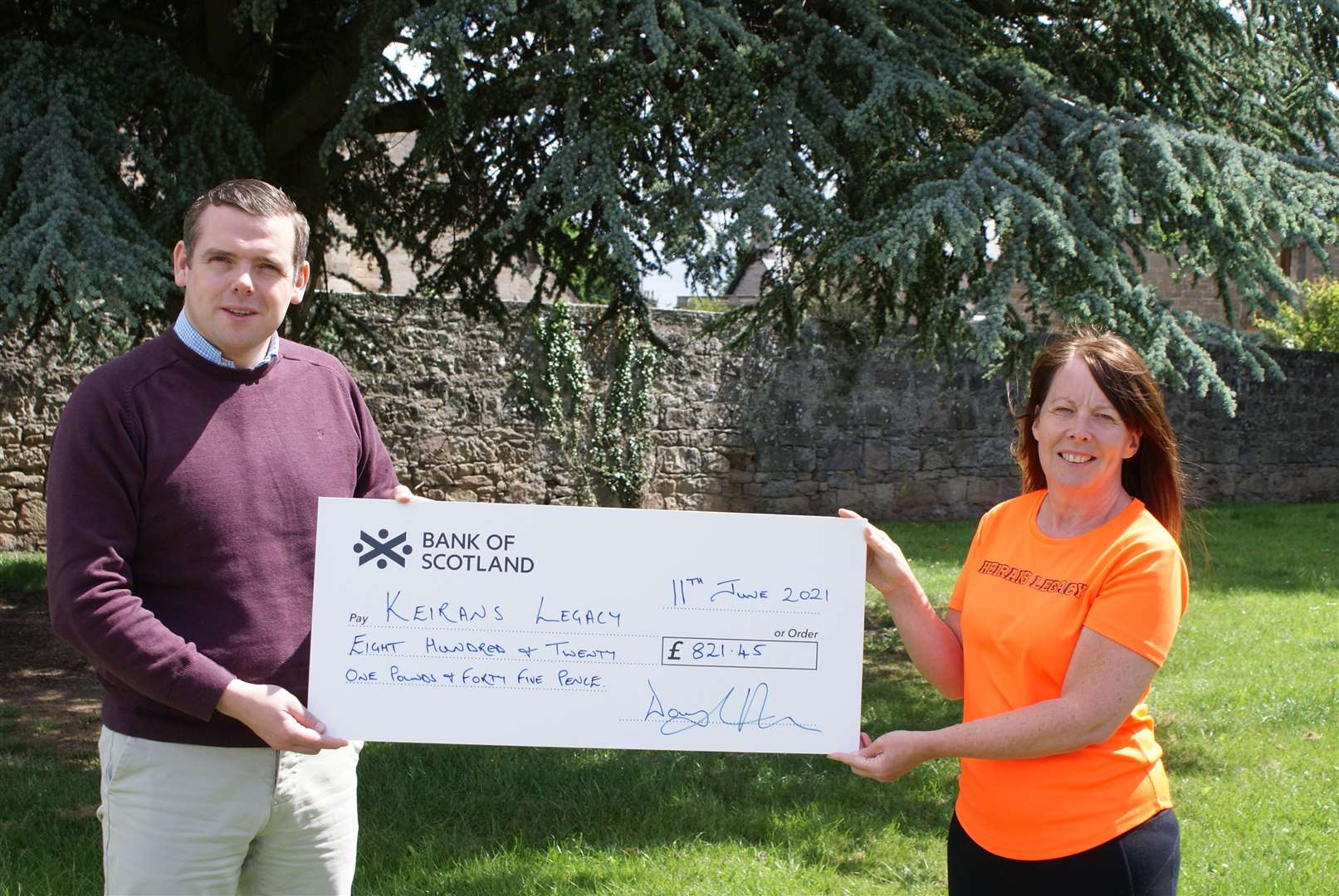 Douglas Ross presents a cheque to Sandra Mckandie of Keiran's Legacy.