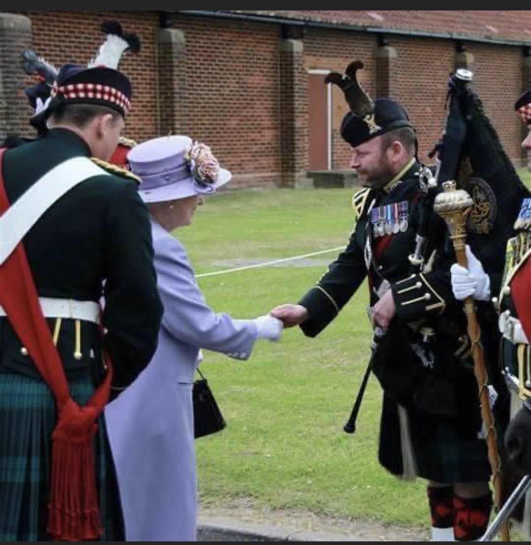 Pipe Major Scott Methven from the Royal Regiment of Scotland shaking hands with Queen Elizabeth II (Scott Methven/PA)