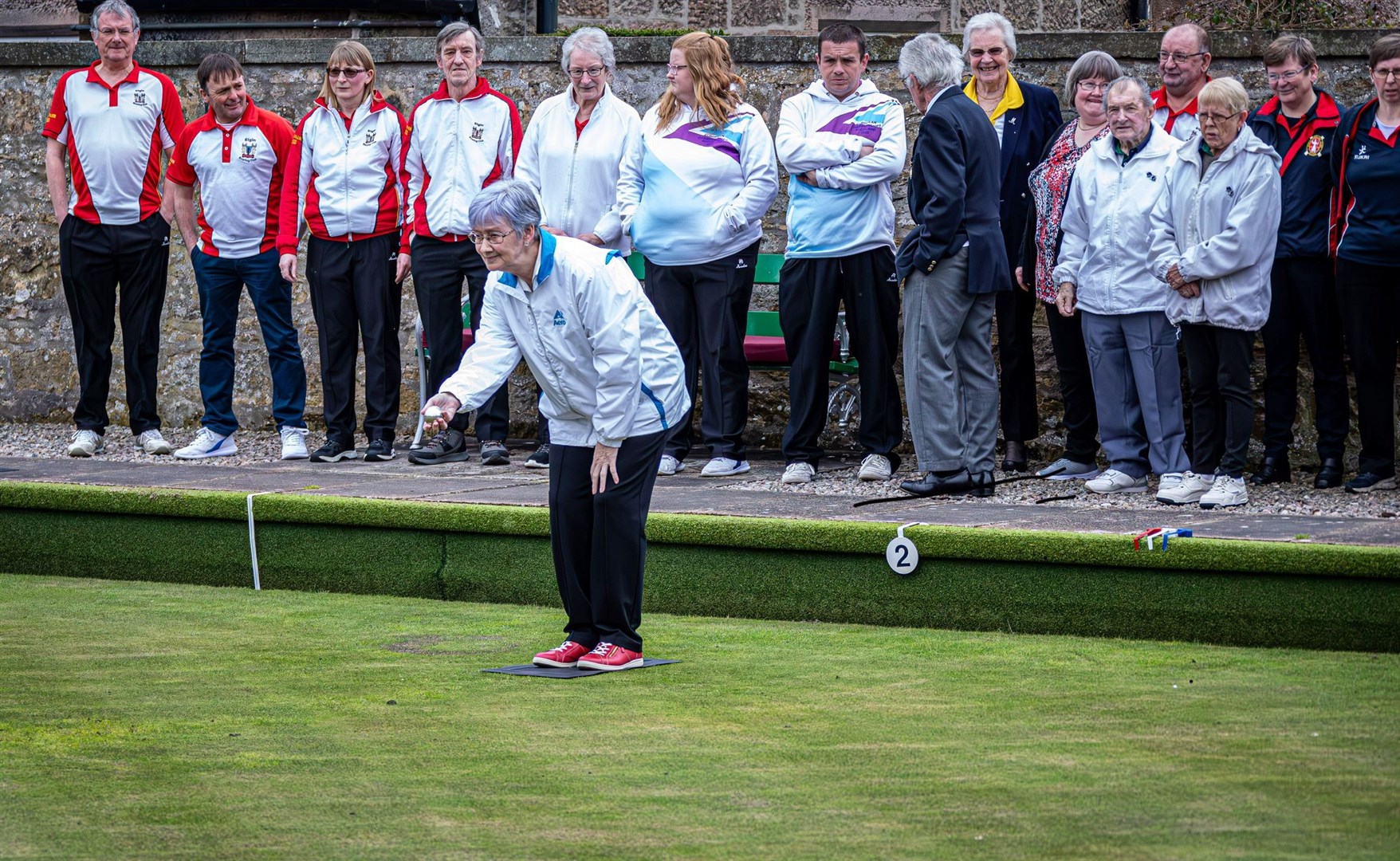 The Elgin Bowling Club president Audrey Gill rolls out the first jack of the season.