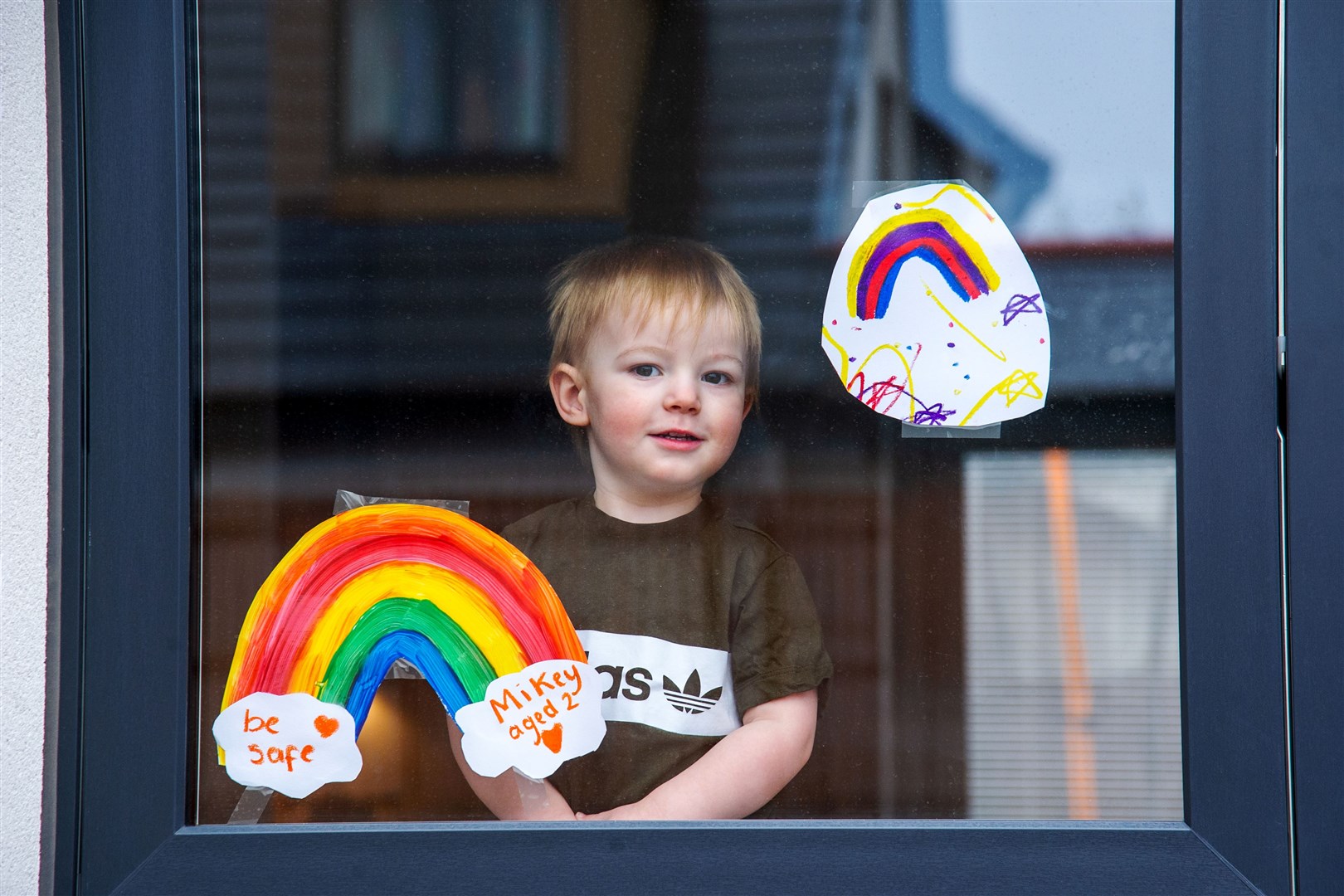 Mikey Gordon alongside his rainbow display...As part of the 'From My Window' movement - people put rainbows in their windows across Moray to spread joy in March. Picture: Daniel Forsyth