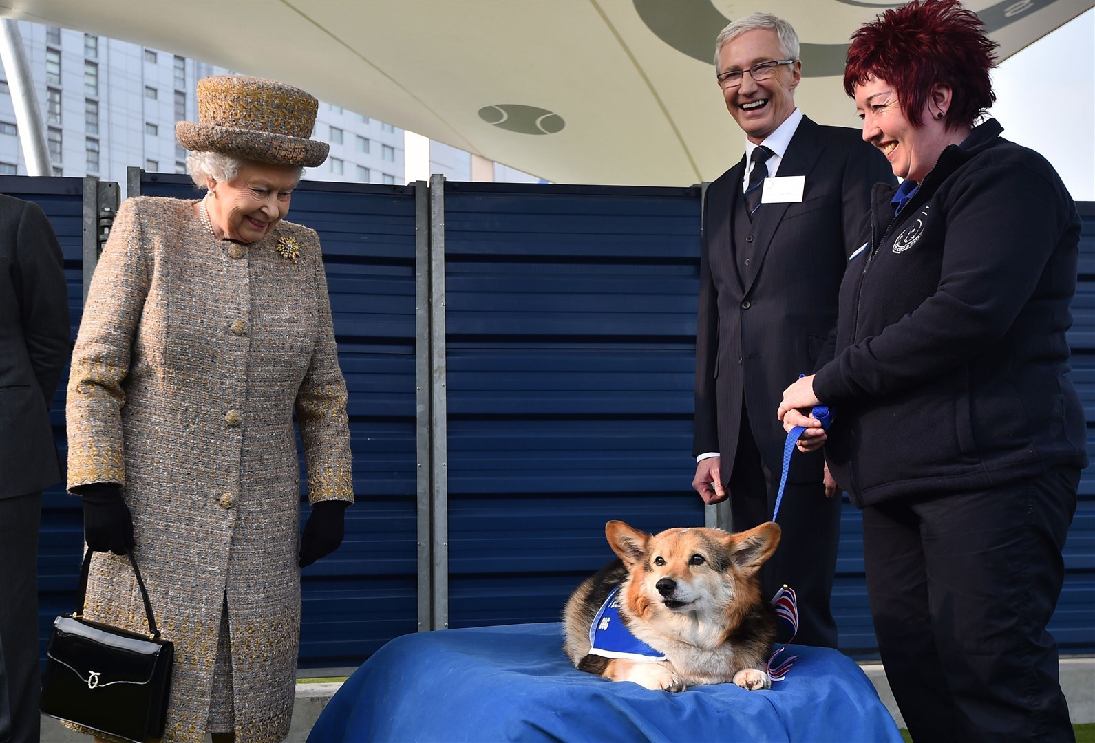 Queen Elizabeth II looking at a Corgi as Paul O’Grady looks on during a visit to Battersea Dogs and Cats Home in London (Ben Stansall/PA)