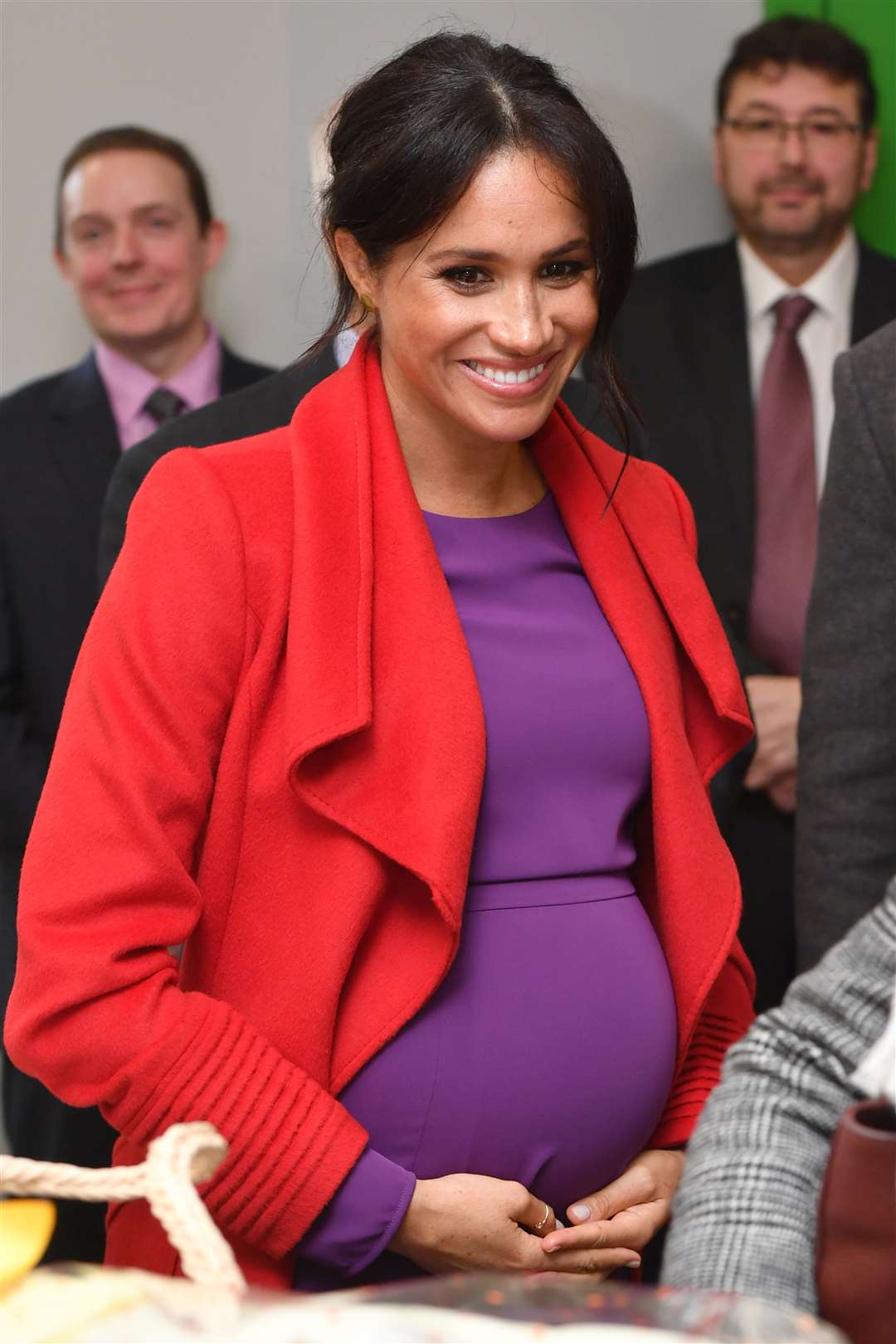 Meghan cradles her bump on a visit to Birkenhead (Anthony Devlin/PA)