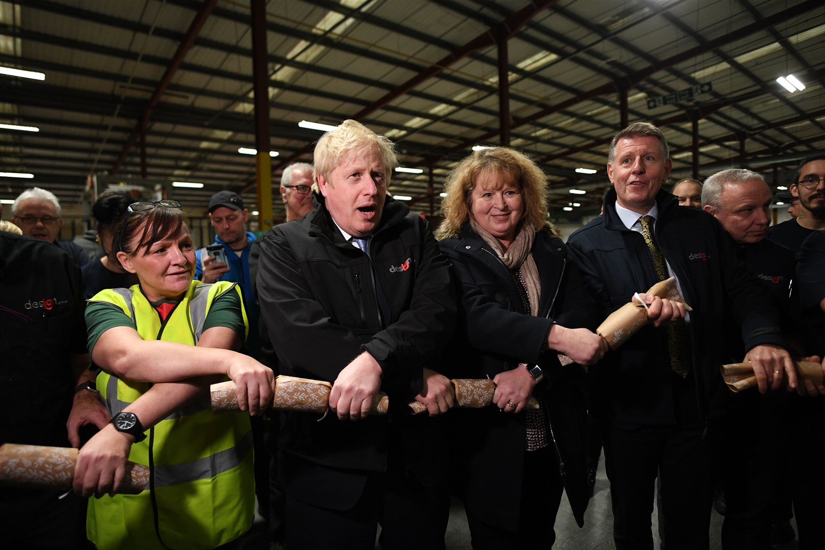 Prime Minister Boris Johnson pulls Christmas crackers with staff during a visit to IG Design Group in Hengoed in 2019 (Stefan Rousseau/PA)