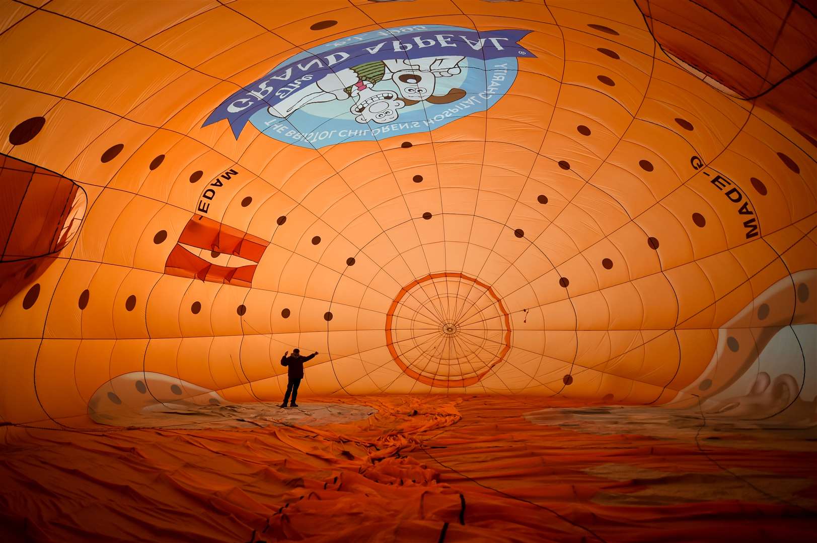 A balloon pilot enters the canopy to check the rigging (Ben Birchall/PA)