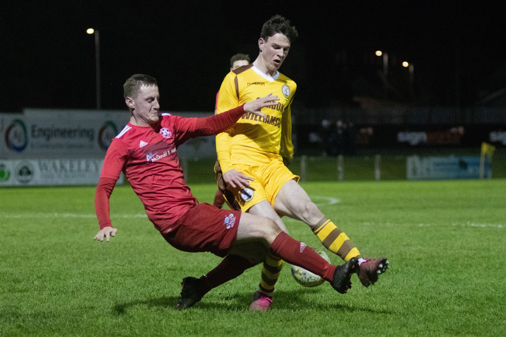 Lossie full back Michael Weir goes in for a challenge on Forres' Ryan Macleman...Forres Mechanics FC (1) vs Lossiemouth FC (0) - Highland Fotball League 22/23 - Mosset Park, Forres 23/12/22...Picture: Daniel Forsyth..