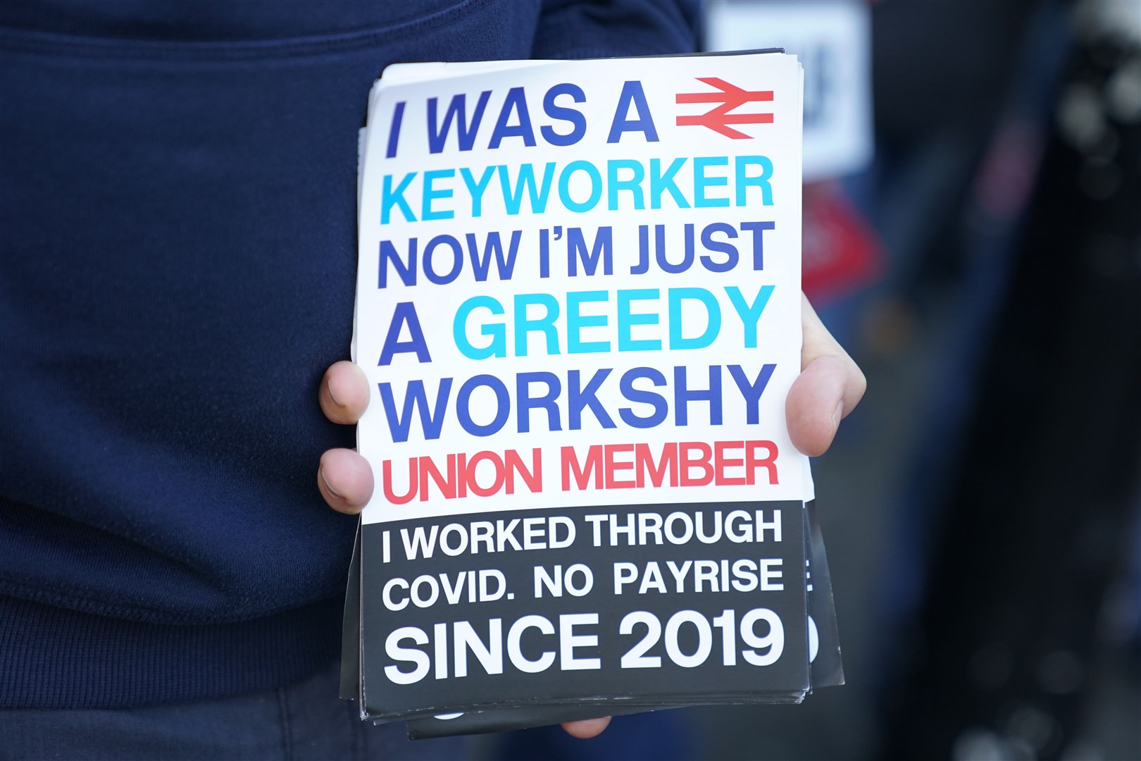 A member of the Aslef union holds a banner on the picket line outside Euston station in London as rail workers take further strike action (Kirsty O’Connor/PA)