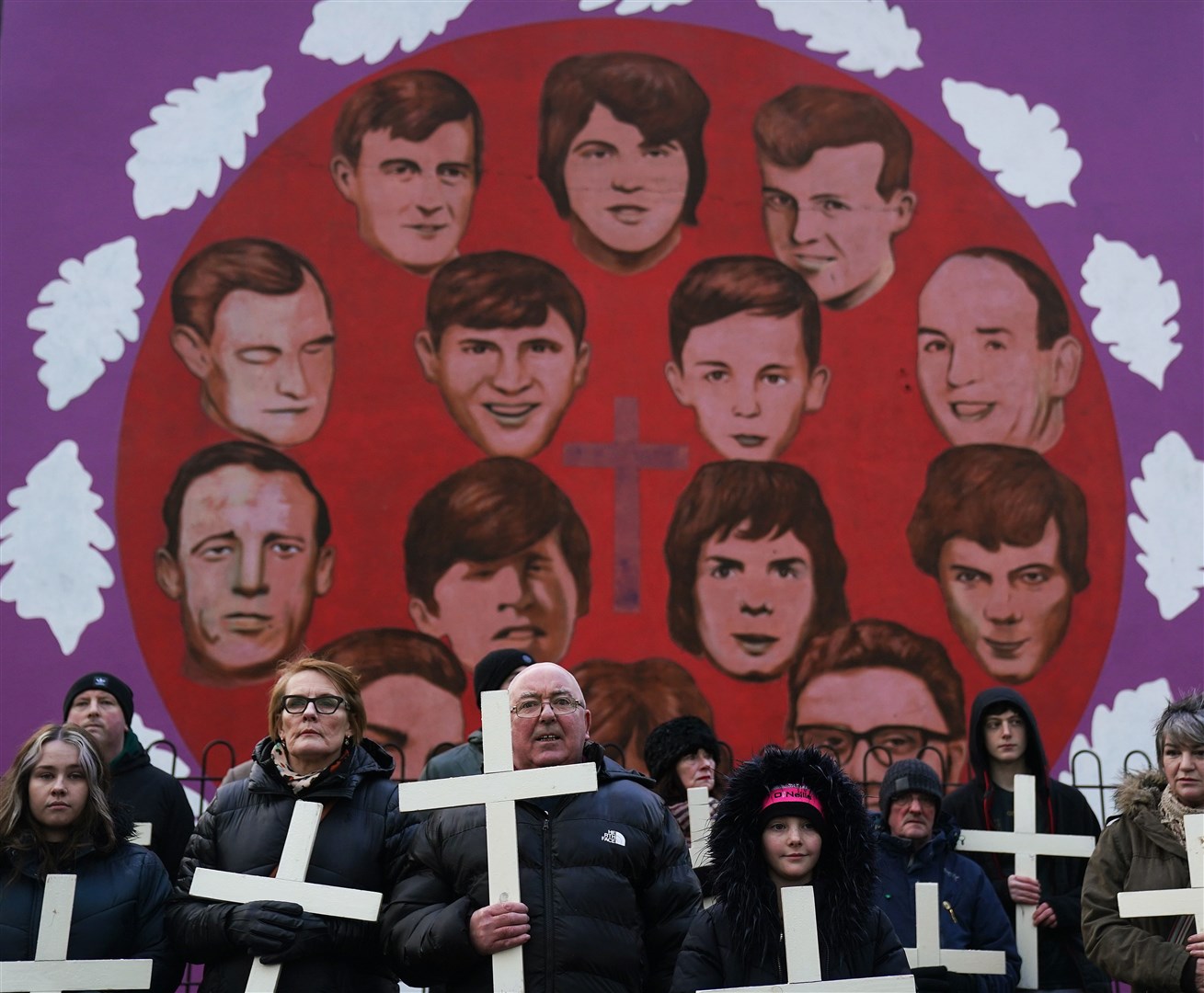 People stop at a mural of the victims of Bloody Sunday during a march to commemorate the 50th anniversary in January (PA)