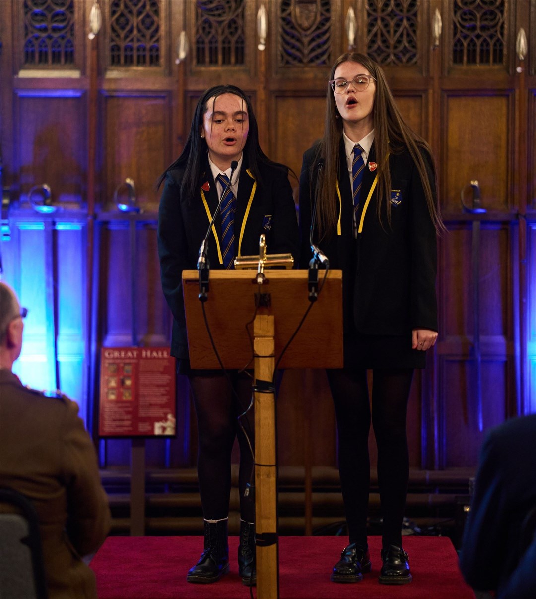 Lossiemouth High School pupils Lily Gilmour and Rhianna Williams singing on stage.