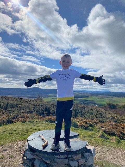 A delighted Thorfinn completes the challenge, pictured at the top of the Bin of Cullen.