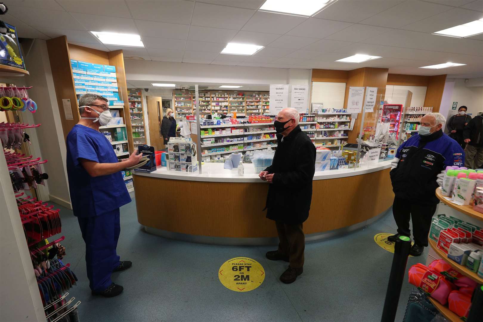 Pharmacist Andrew Hodgson (left) speaks to Robert Salt (centre), 82, before he receives an injection of the coronavirus vaccine at Andrews Pharmacy in Macclesfield (Peter Byrne/PA)