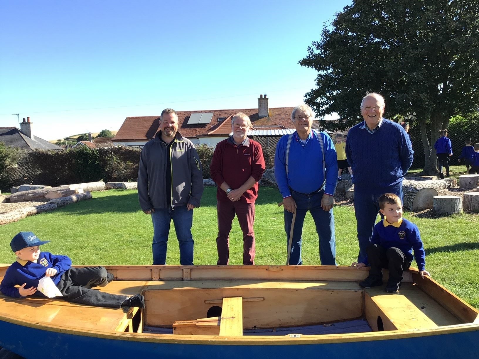 Time for a lounge in the dinghy while the boatbuilding team look on. Picture: Cullen Primary