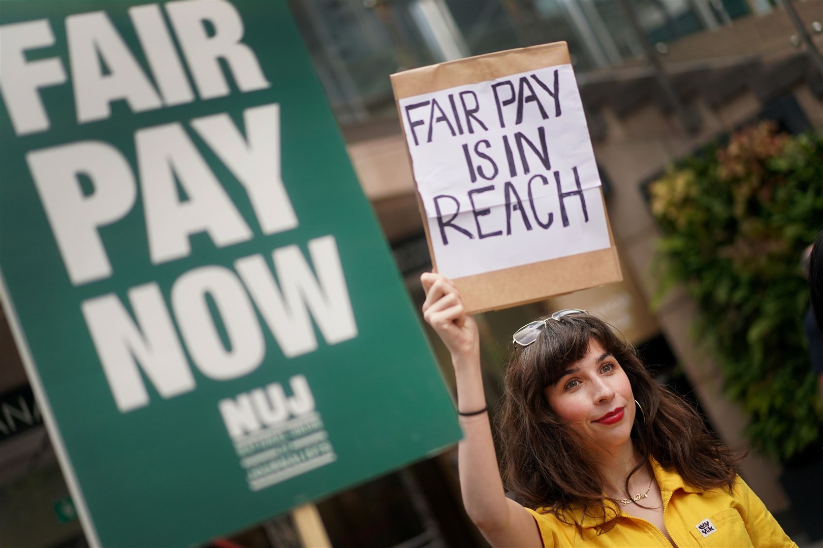 A member of the National Union of Journalists on the picket line outside the offices of Reach Plc in Canary Wharf, London (Victoria Jones/PA)