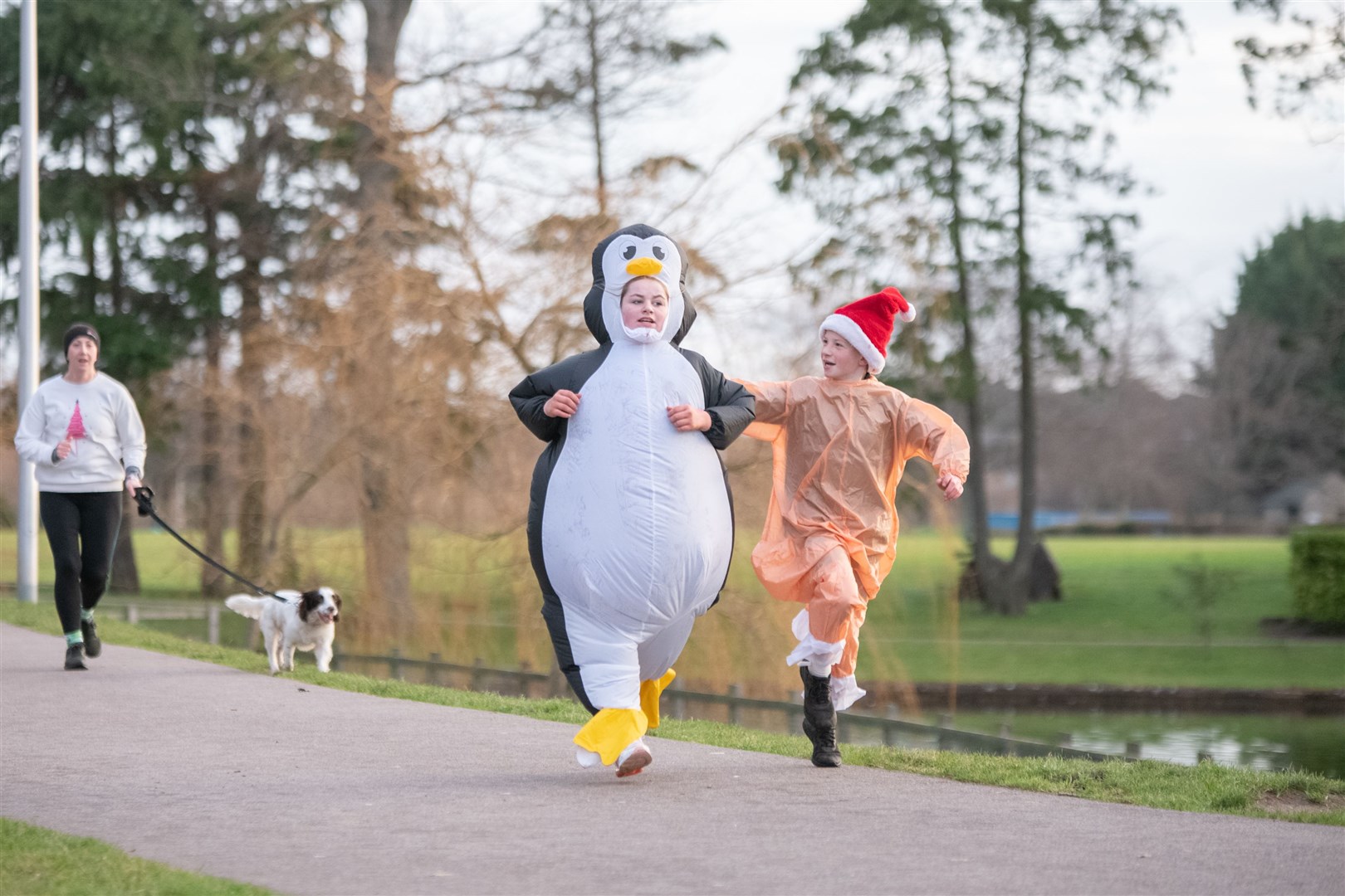 Dressed as a penguin is Chloe Munro and turkey Millar Munro...Elgin Christmas Day parkrun 2023...Picture: Daniel Forsyth..