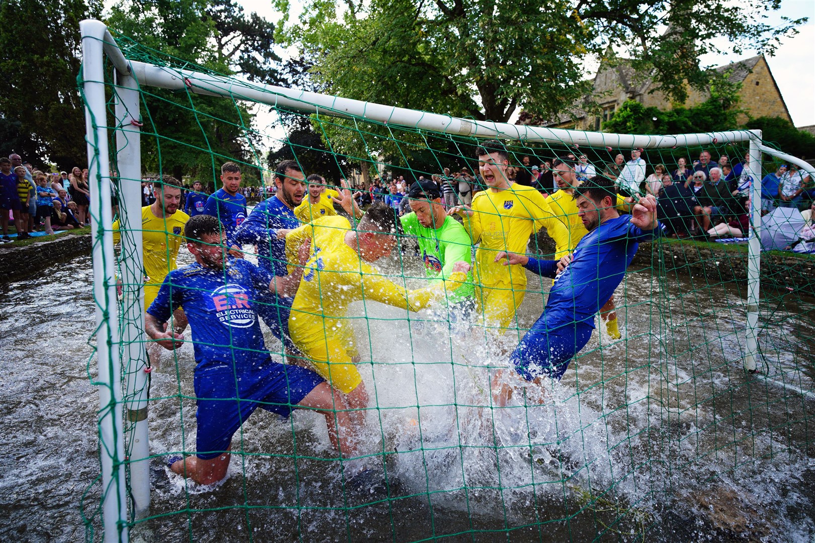 Footballers from Bourton Rovers create a splash as they fight for the ball during the annual River Windrush football match, which has been taking place for more than 100 years in the Cotswolds village of Bourton-on-the-Water, Gloucestershire (Ben Birchall/PA)
