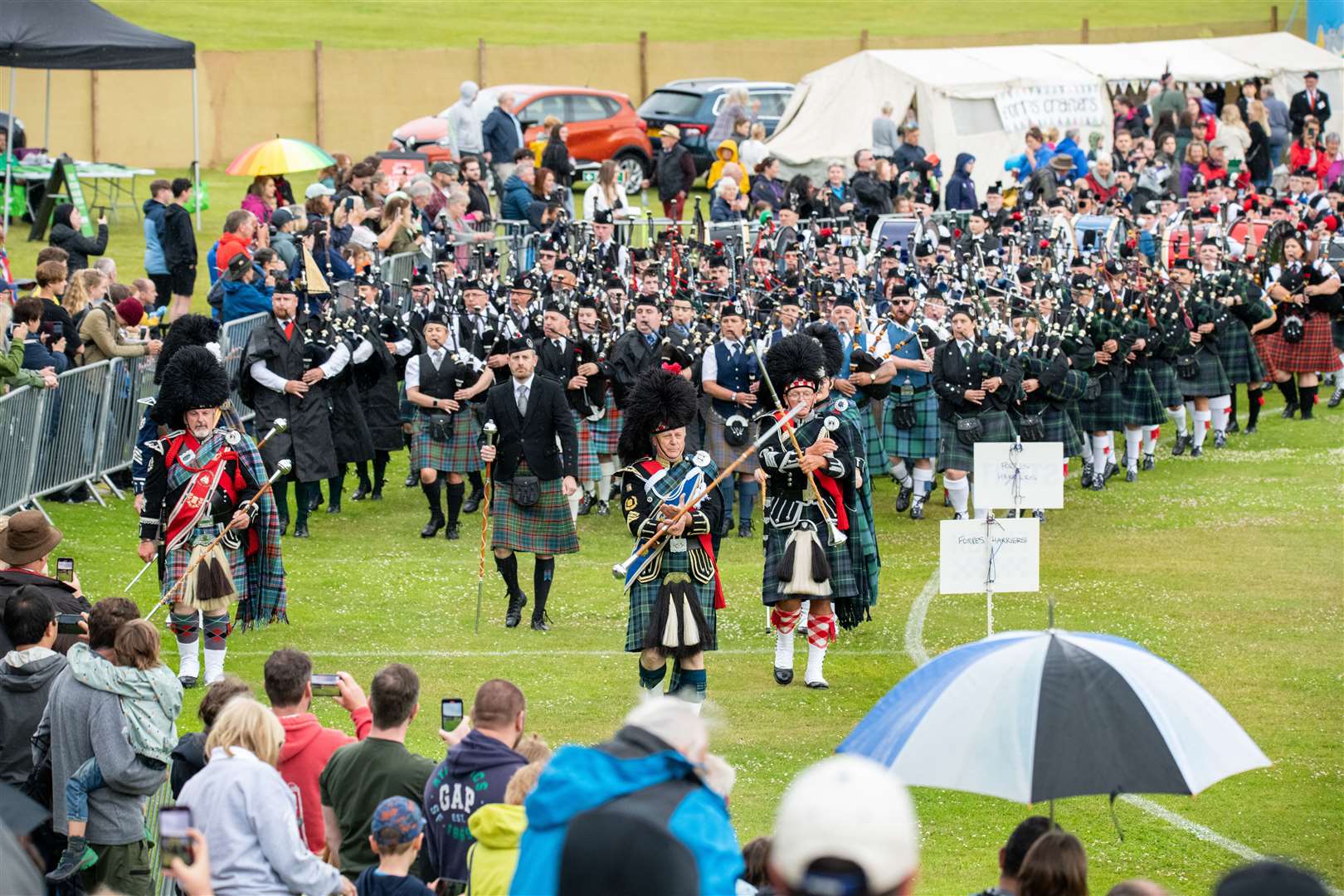The Massed Pipes and Drums make their way around the Grant Park arena...Forres Highland Games 2022...Picture: Daniel Forsyth..