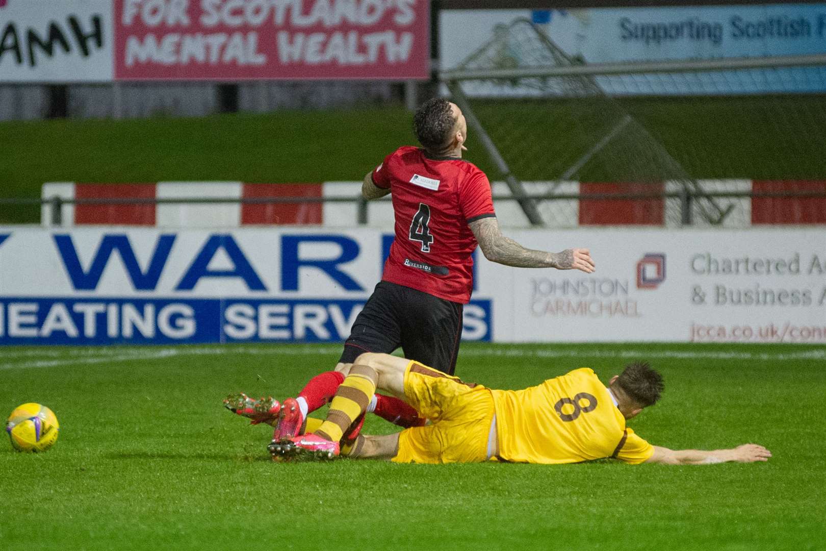 Forres new boy Jack Grant puts in a tackle on Darryl McHardy, leading to the Elgin player being stretchered off. Picture: Daniel Forsyth..