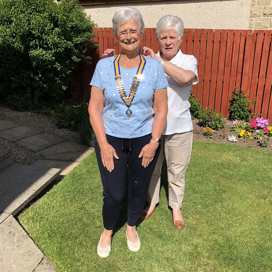 The Inner Wheel Club of Elgin's outgoing president, Edna Ross, presents the chain of office to new president, Pam Sutherland.