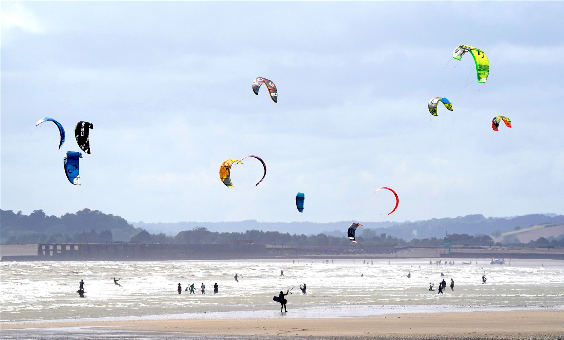 Kite surfers enjoy the windy weather at Camber Sands, East Sussex (Gareth Fuller/PA)