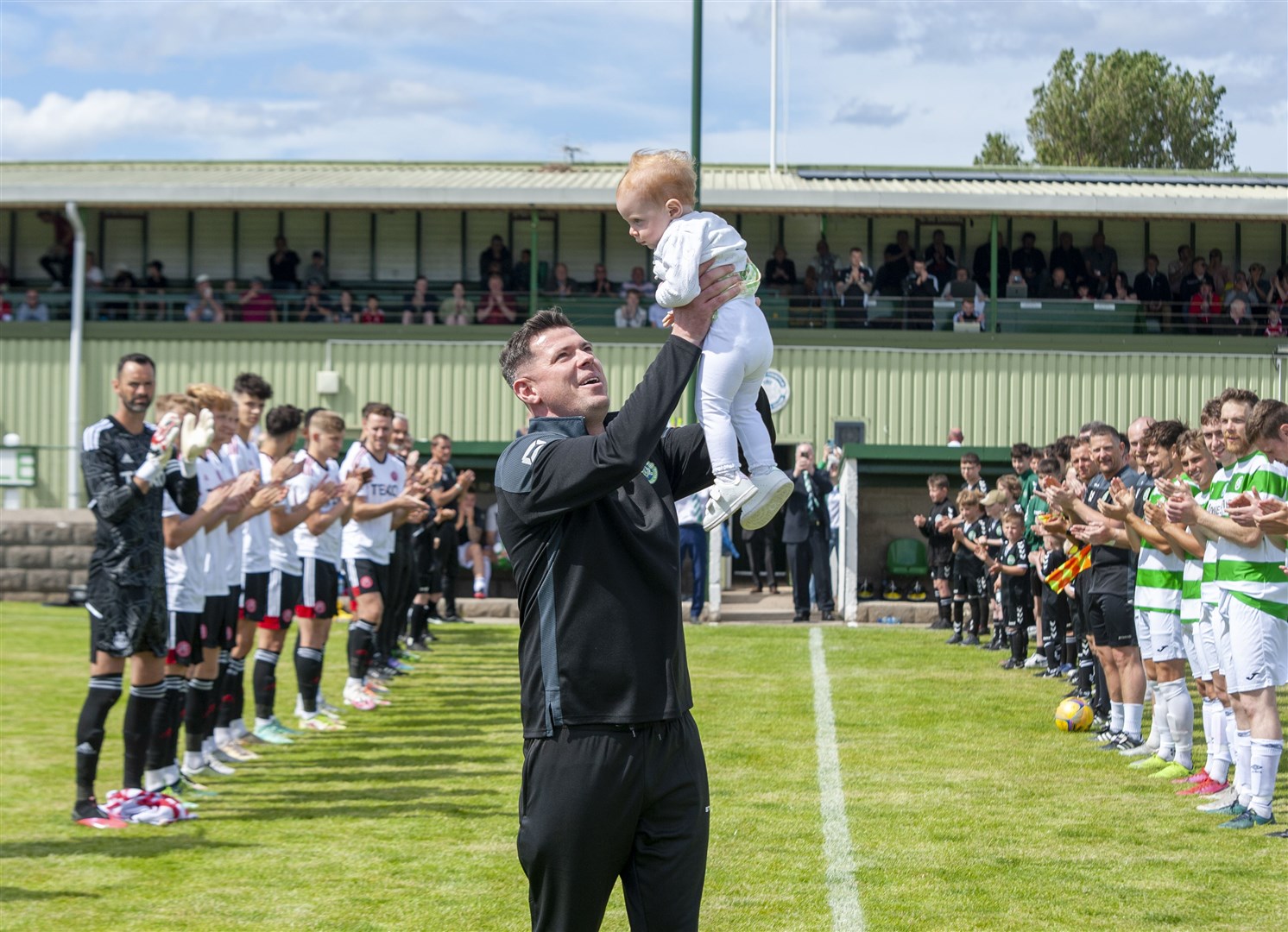 Graeme Stewart holds his young daughter aloft after being given a guard of honour by the players before the game. Picture: Allan Robertson