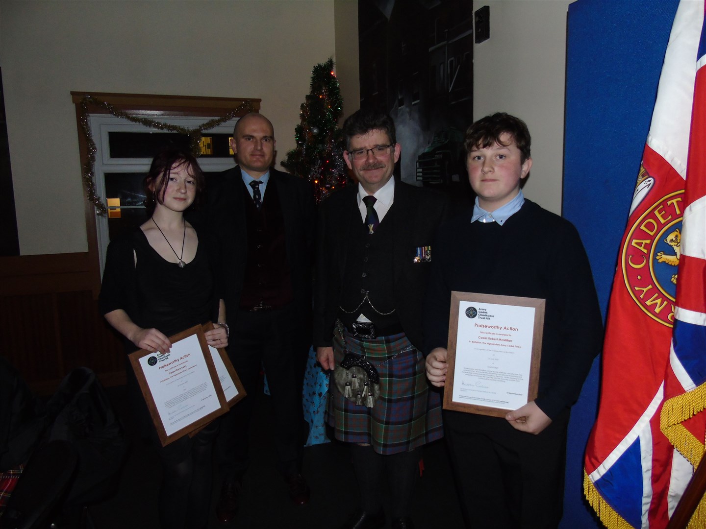 Cadet Zara Laws (left) and Cadet Robett McMilliam (right) accept their certificates alongside Commandant Colonel Mike MacDonald (second right) and Moray Company Commander Lt Andrew Peacock.