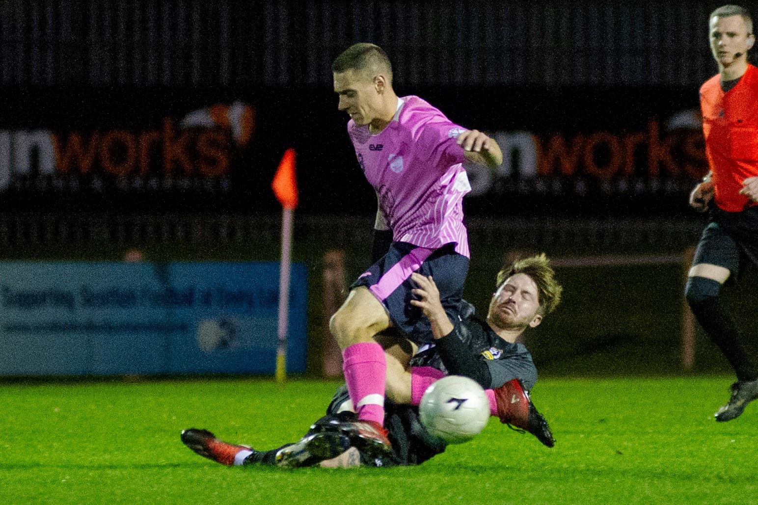 Carisbrooke midfielder Scotty Moore goes in for a challenge on Mental Mechanics' Ross Cooper... Picture: Daniel Forsyth..