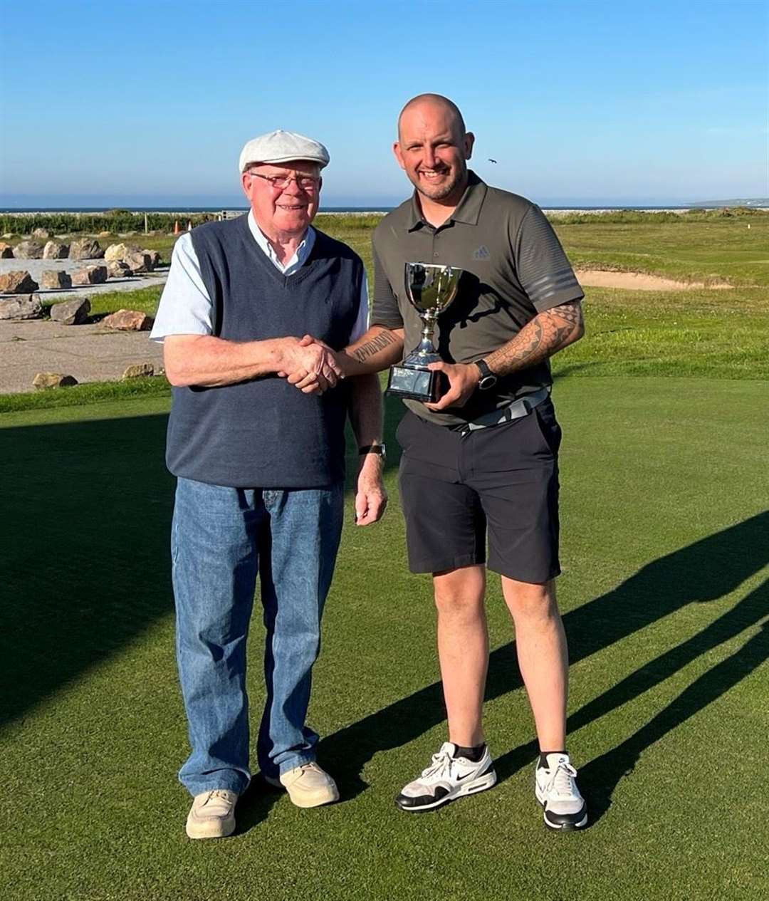 Jim Gordon (left) presents the Scratch Section trophy to Iain Ross. Picture: Spey Bay GC