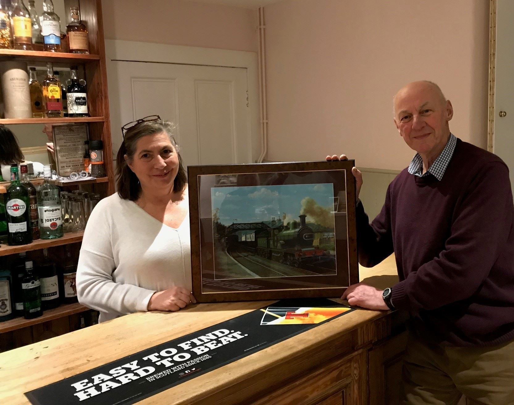 John Diffey, from the Great North of Scotland Railway Association, presents the Craigellachie Station print to Alison Hunter, new owner of the Fiddichside Inn.