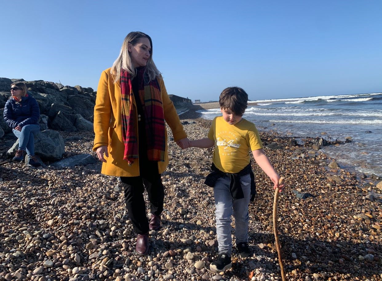 Karen Adam MSP enjoys a stroll down the beach with son Isaac.