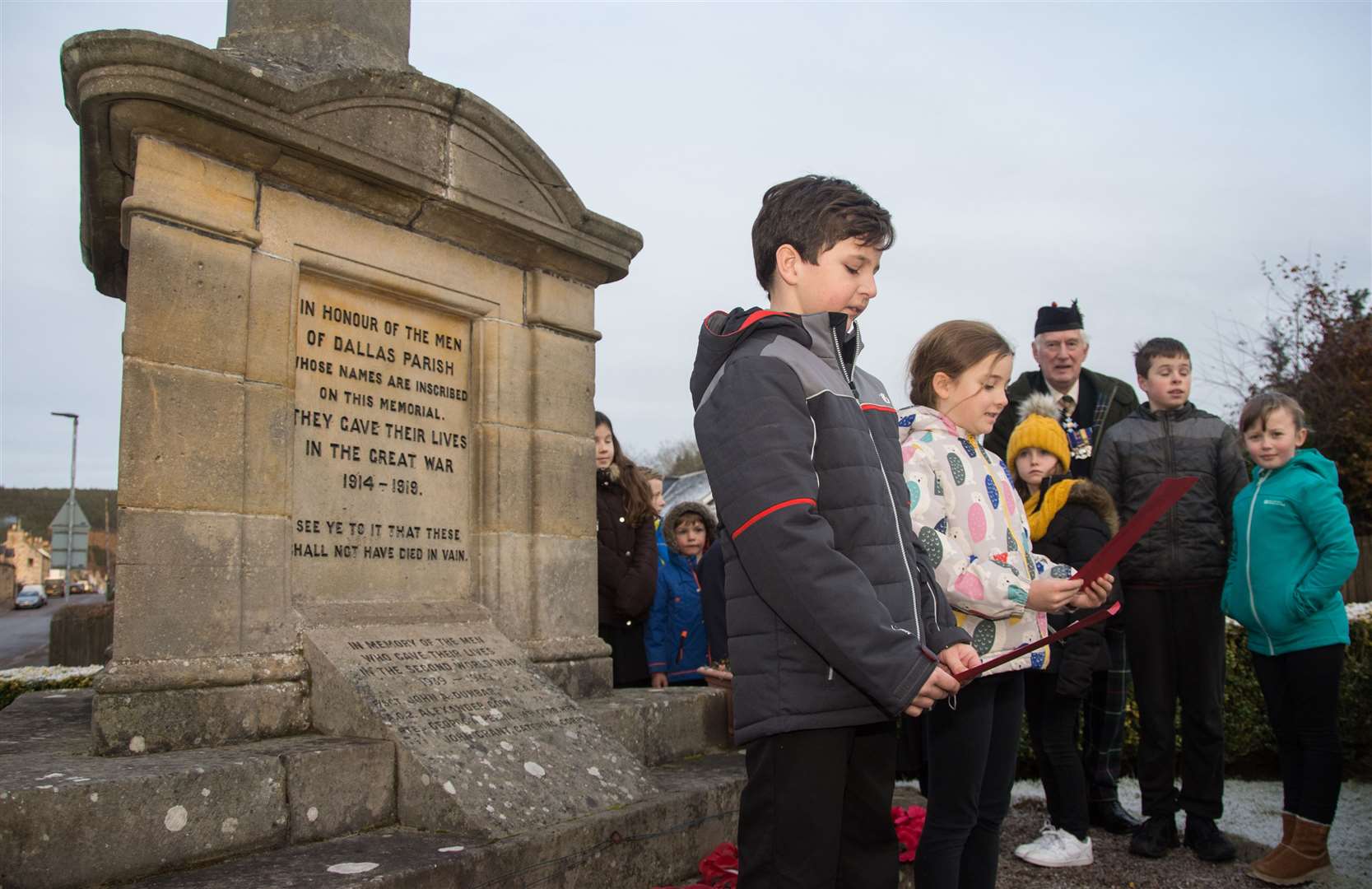 This War Memorial was ultimately built in Dallas. Pupils from the village's primary school are pictured honouring those who died in the conflict. Austin Davis and Eva Landy read out a poem in their memory. Photograph by Becky Saunderson.