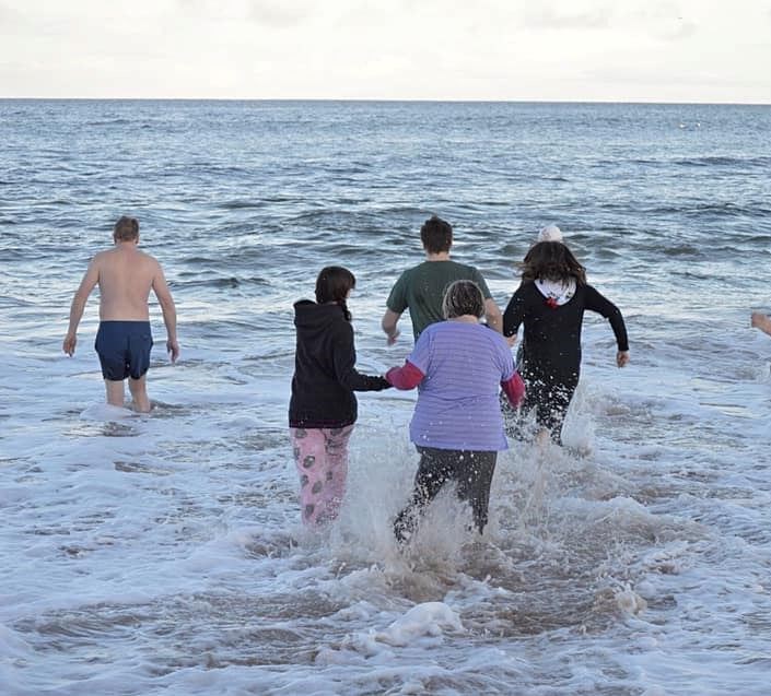 Participants in Hopeman's 2nd Loony Dook dash into the sea.