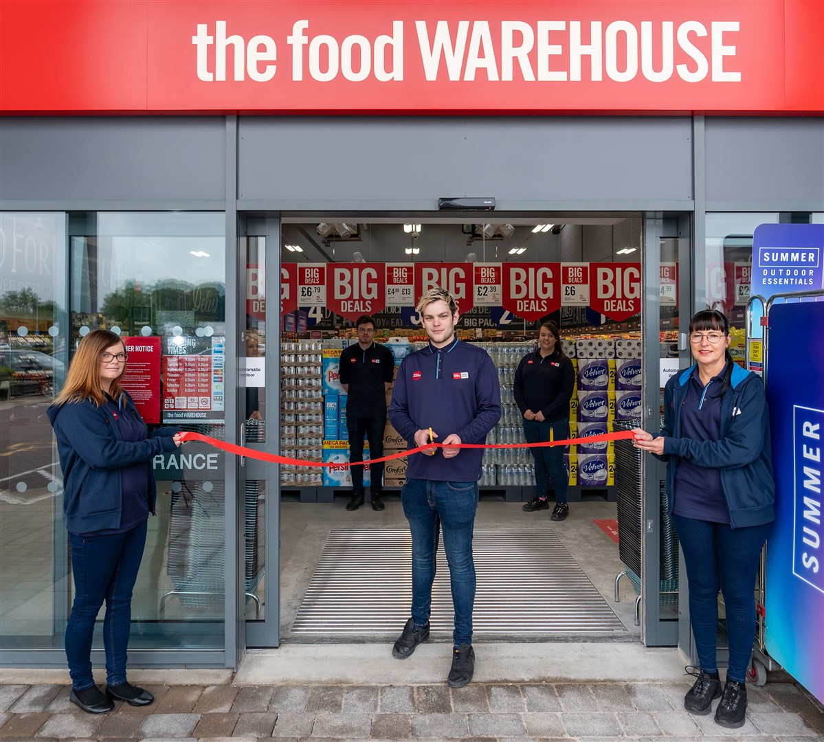 Store manager Michael Whaite cutting the opening ribbon with Catherine Harrison and Catherine McCready.