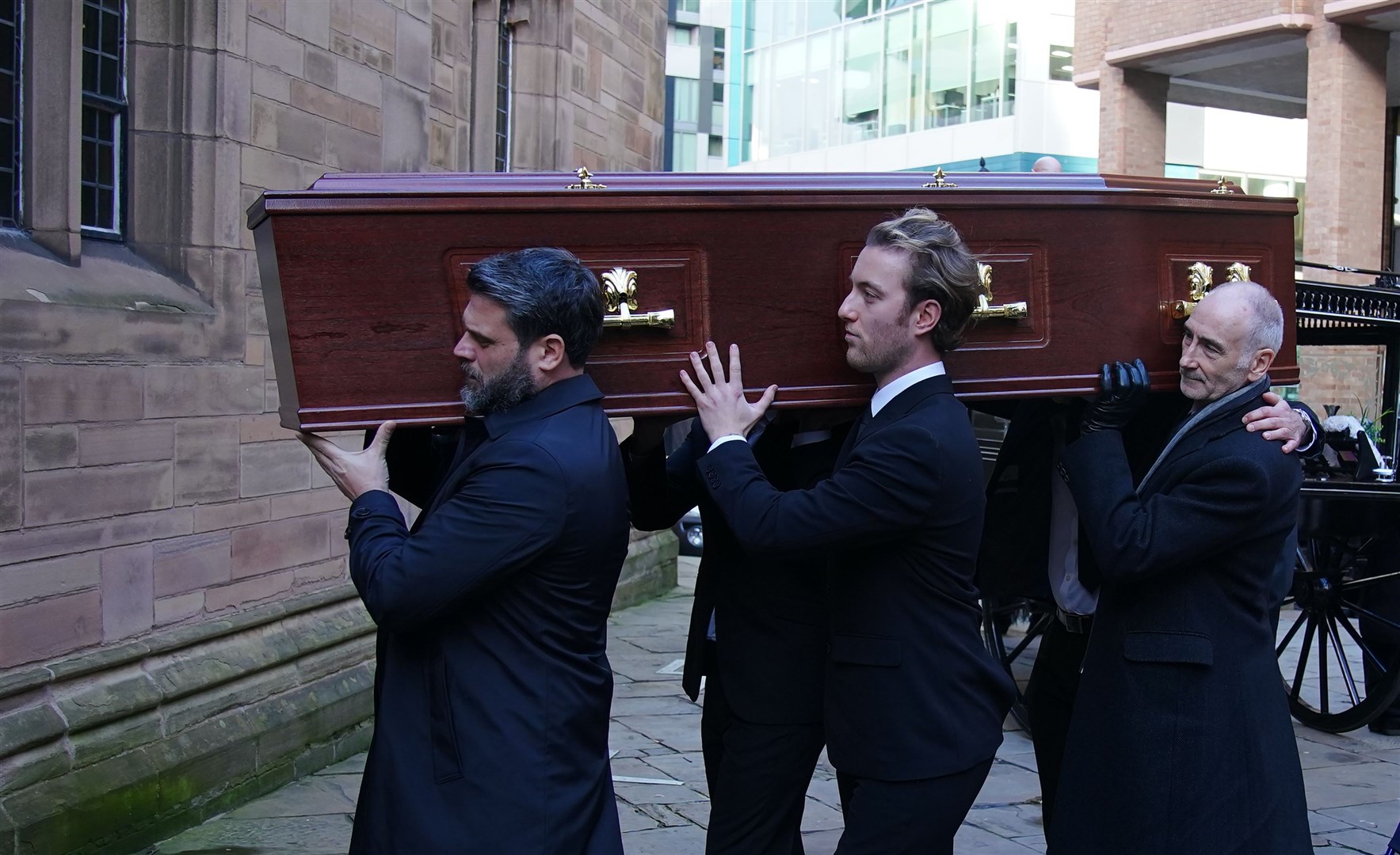 Pall bearers carry the coffin into the funeral for former Brookside actor Dean Sullivan (Peter Byrne/PA)