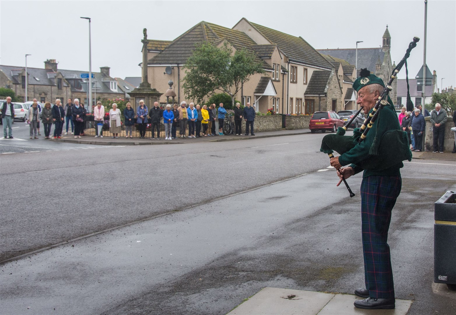 Piper Patrick Glendinning and a small crowd gathered outisde Burghead Chruch to pay their respects to the victims of the Stonehaven Train Crash including Chris Stuchbury who has family in Burghead...Picture: Becky Saunderson..