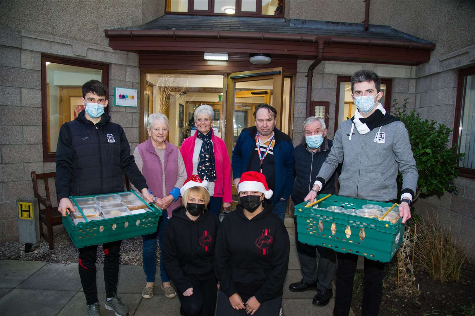 Elgin City player Rory MacEwan (left) and general manager Keiran Carty (right) join Salt Cellar staff to handover meals to West Park Court residents. Picture: Becky Saunderson