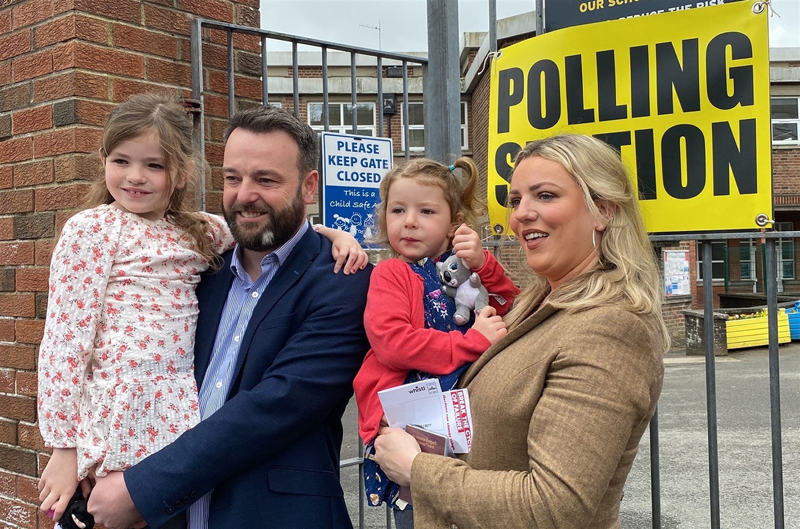 SDLP leader Colum Eastwood arrives to cast his vote with his wife and children in the Foyle constituency in Londonderry (PA)