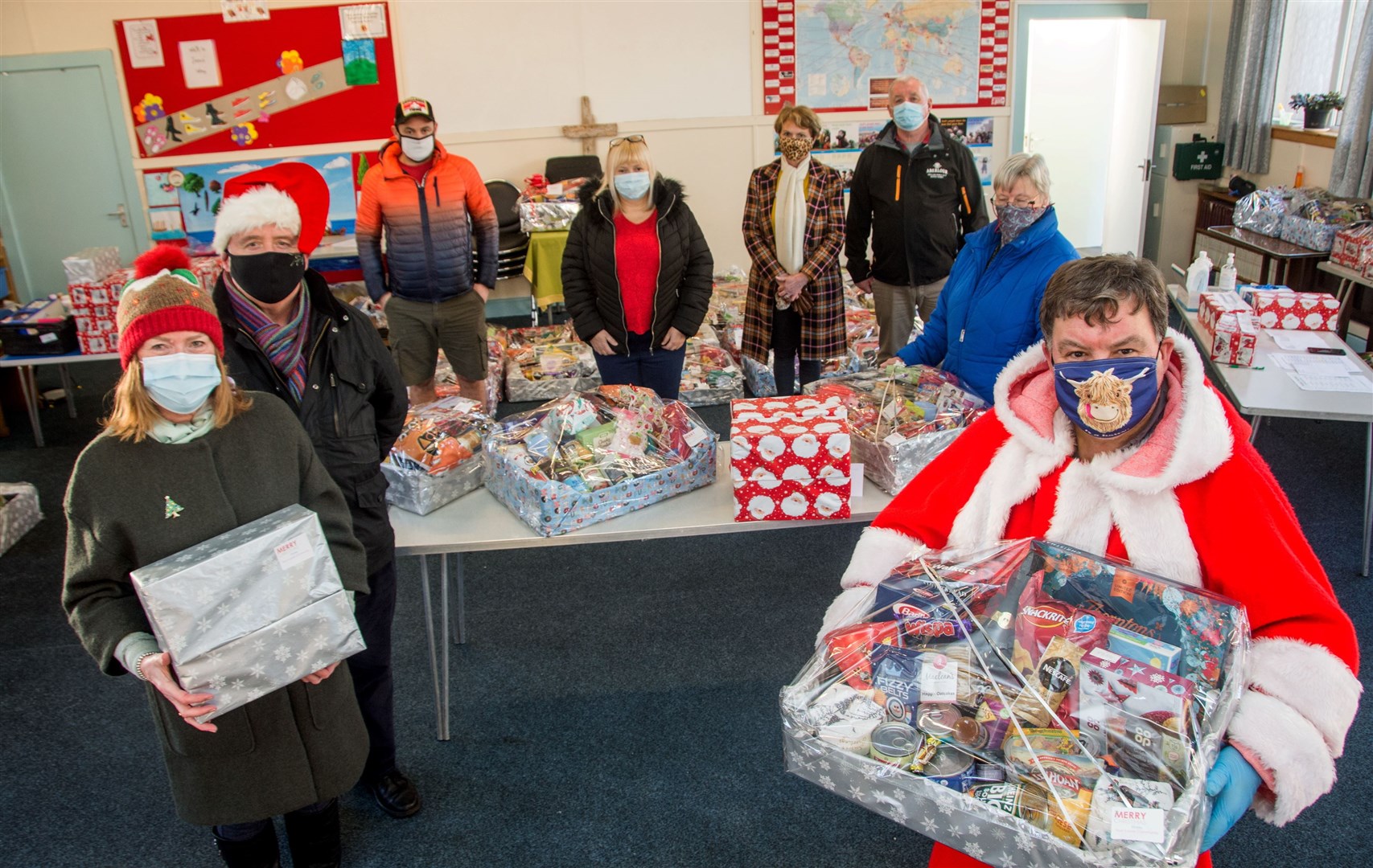 Lossiemouth Community council have been delivering food hampers, gift boxes and christmas meals to the communtiy in Lossiemouth. Volunteers Rab and Sheila Forbes (front left) and Neil Cameron (right) with more volunteers behind.Picture: Becky Saunderson