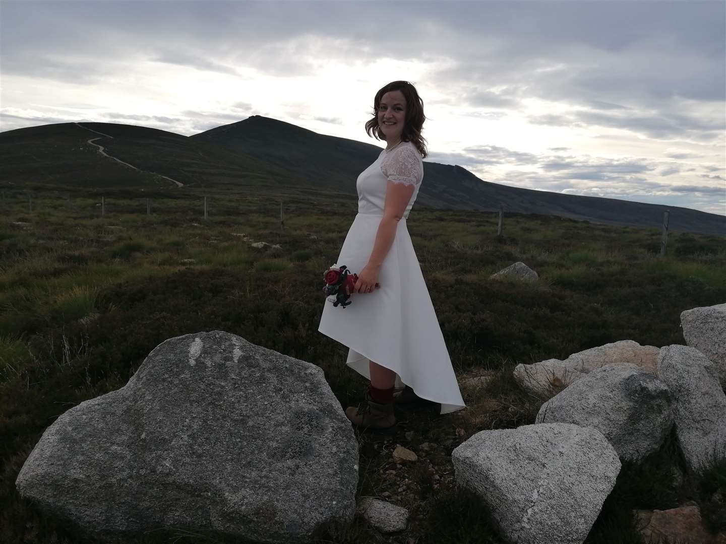 Sarah looks stunning in her wedding dress and hiking boots.