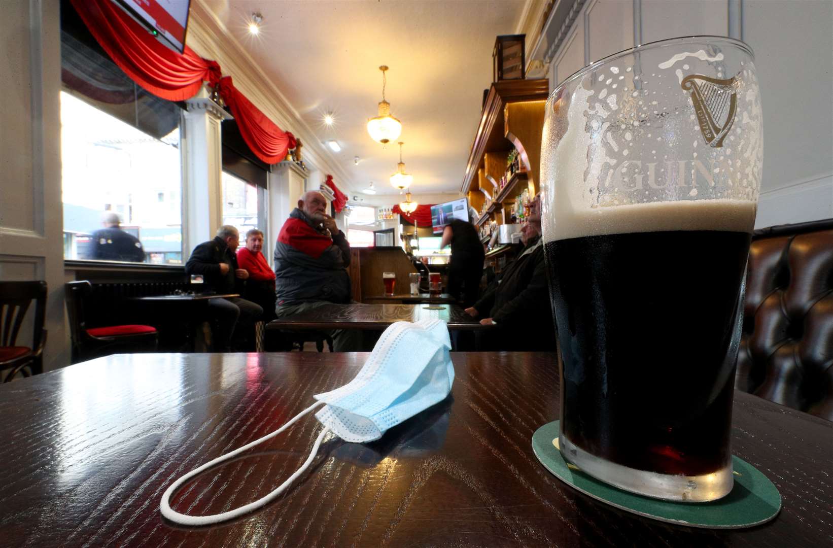 A close up of a pint of Guinness and a face mask on a table in the Richmond pub in Liverpool (Peter Byrne/PA)